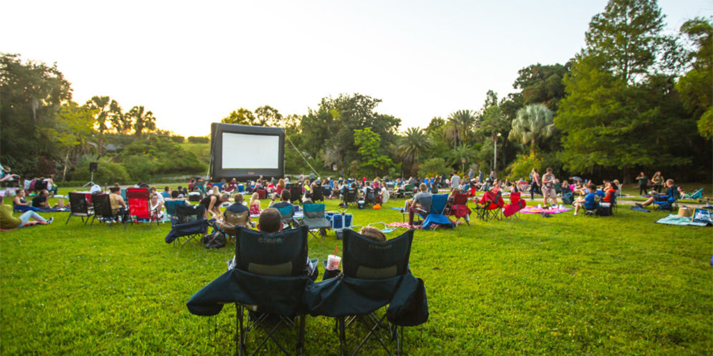 People sitting in chairs waiting for a movie to start at Leu Gardens.